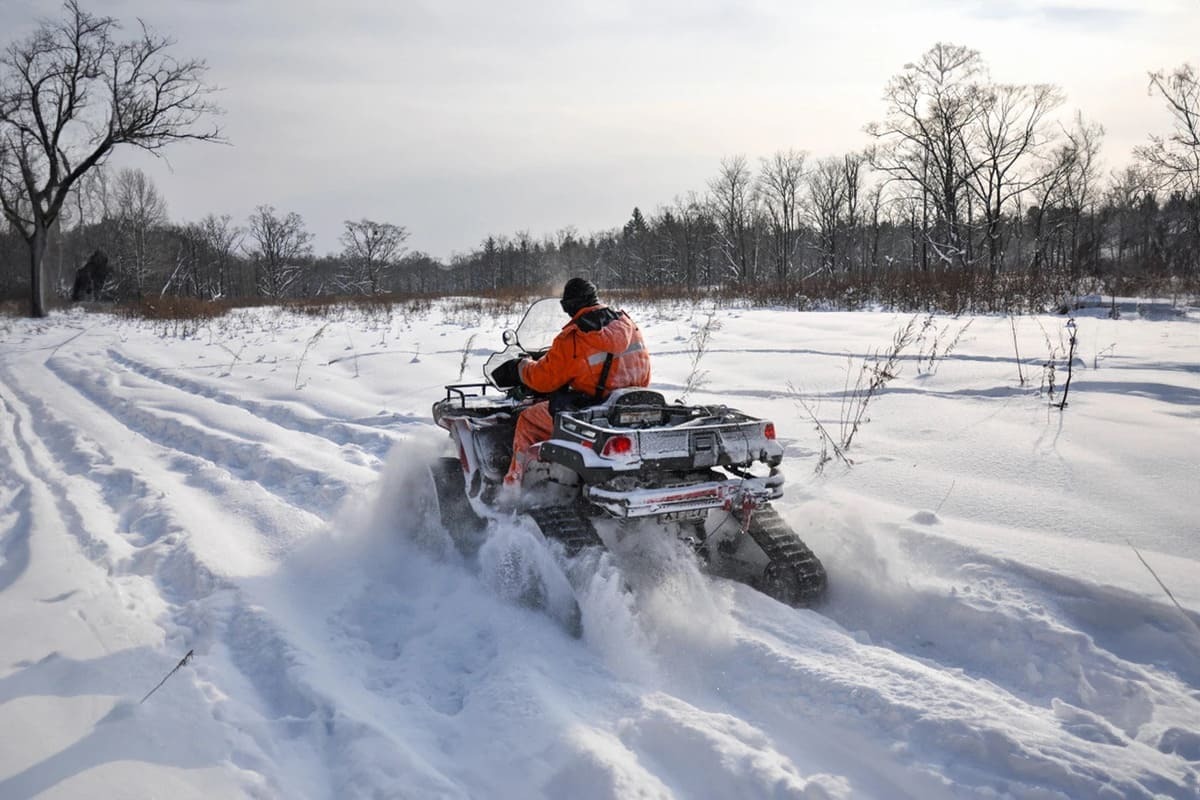 pasionat de atv conducand prin zapada cadouri de craciun pentru iubitorii de atv