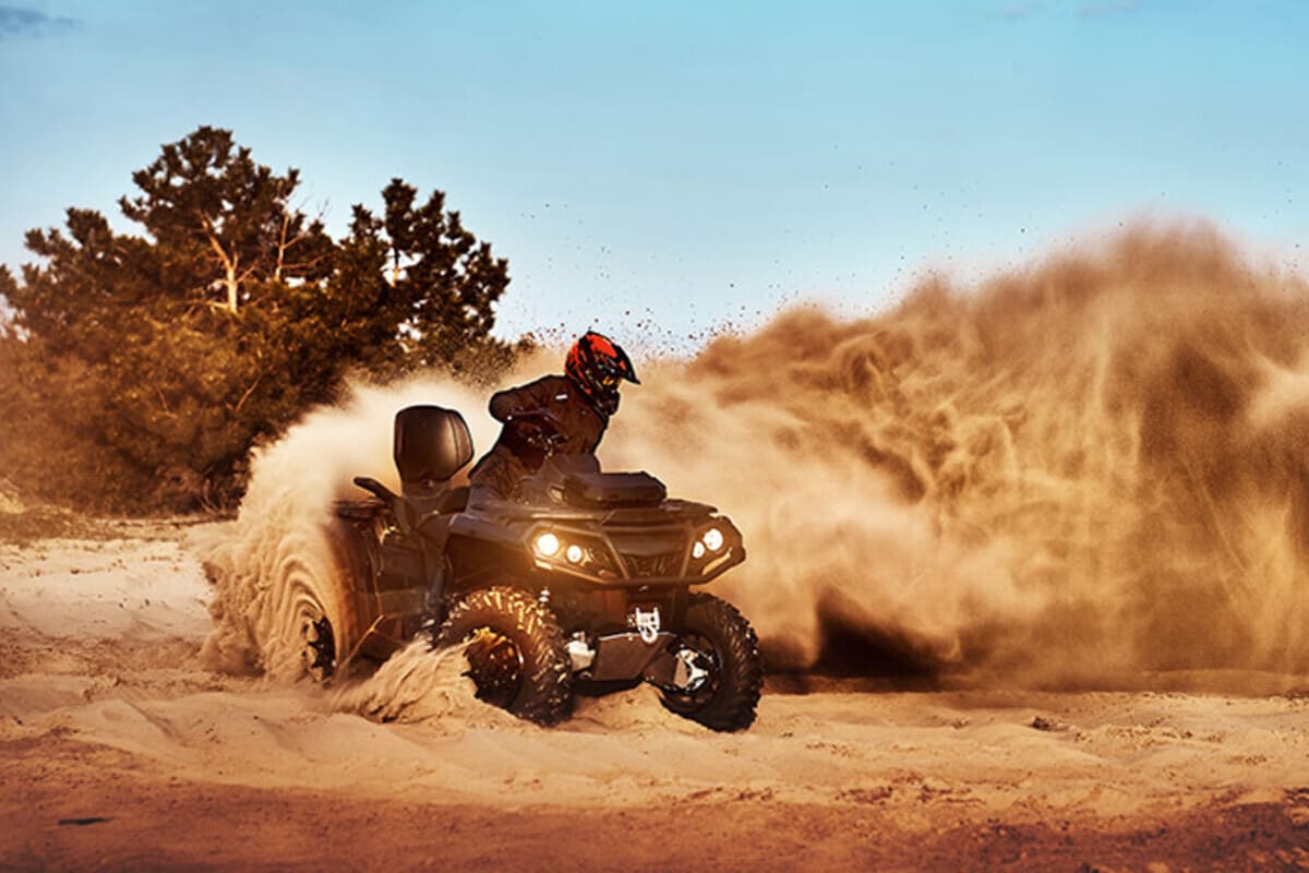 persoana care se plimba cu ATV-ul in nisip